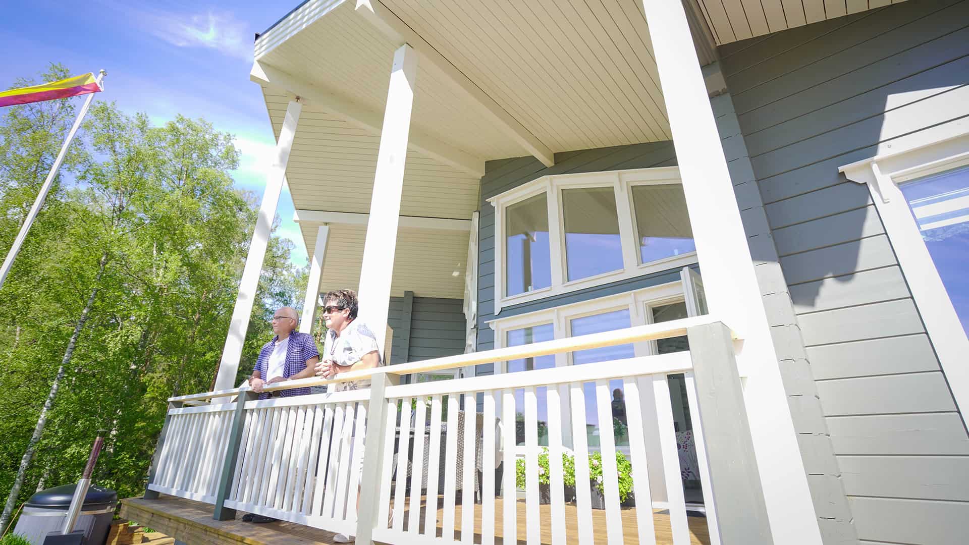 The terrace of log villa Nuuna with two people standing on it.