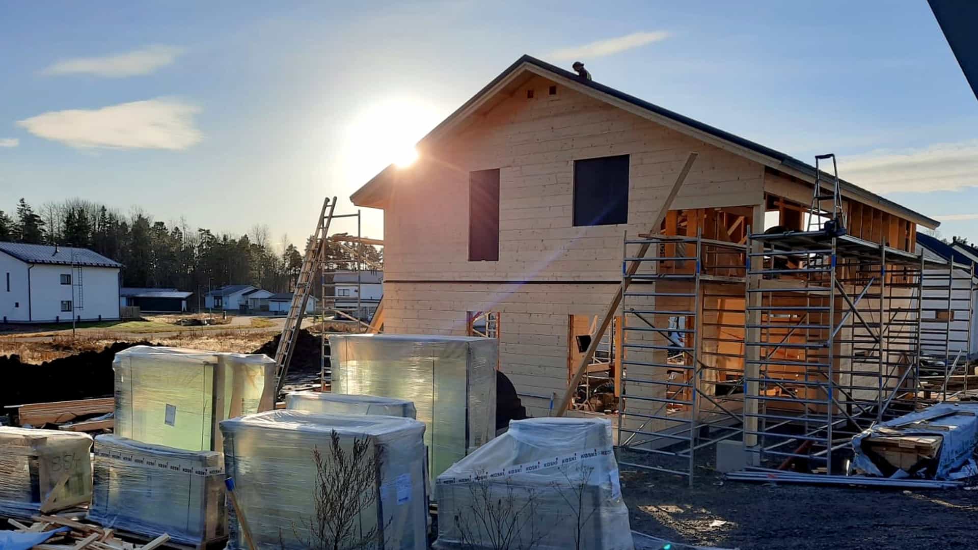 Kuvassa rakennusvaiheessa oleva kaksikerroksinen hirsitalo, jossa on harjakatto. 