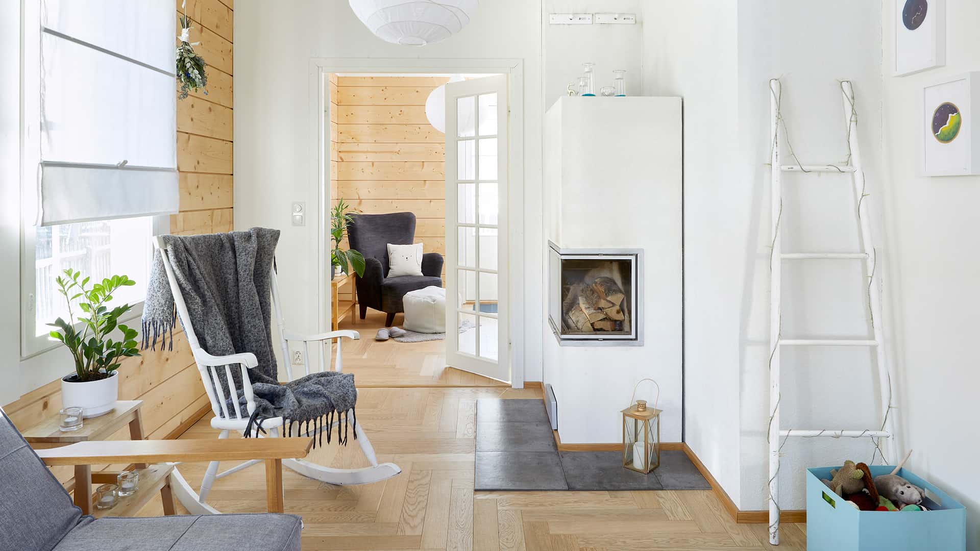 There is a white fireplace and a rocking chair in the living room.