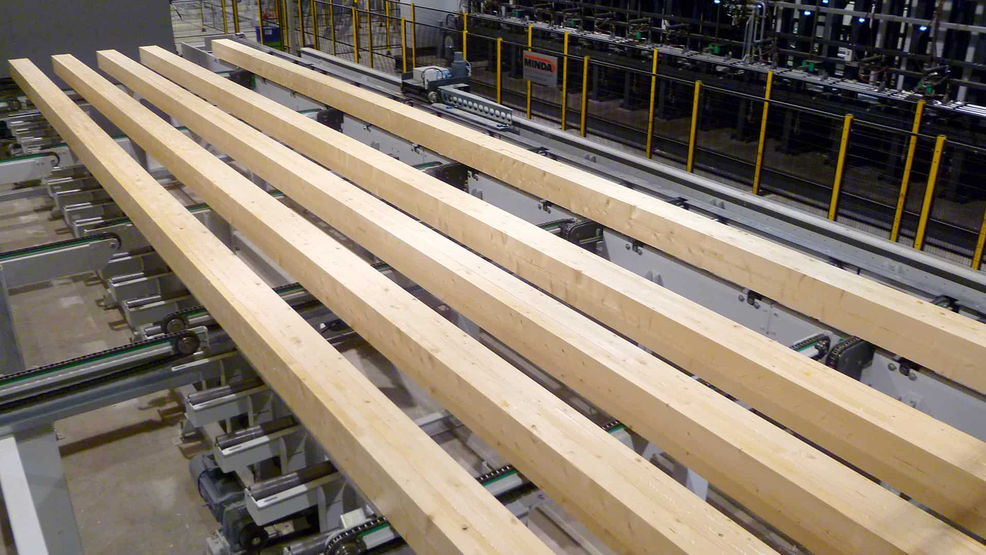 Laminated logs on the Pölkky production line after gluing. From here they move on to planing and profiling.