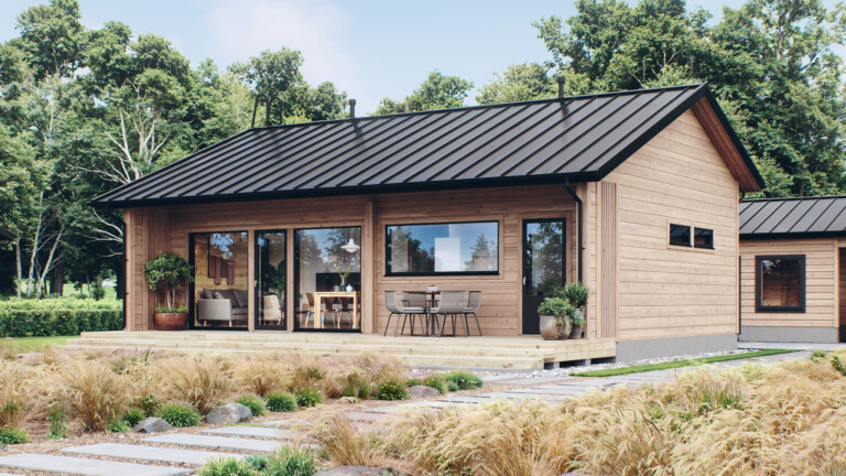 Harjakattoinen hirsitalo, jonka koko talon levyisen terassin sivuilla on suojaa tuovat seinämät.