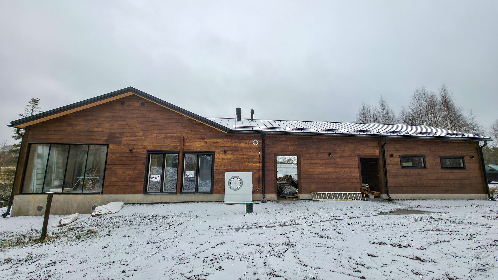 Vastavalmistuneen hirsitalon julkisivu pilvisenä talvipäivänä.